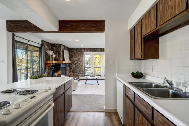 a kitchen with stainless steel appliances granite countertop a sink stove and cabinets