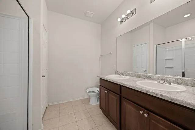 a bathroom with a granite countertop sink a toilet and a mirror