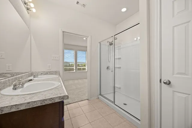 a bathroom with a granite countertop sink a mirror and shower