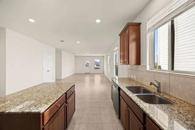 a kitchen with granite countertop a sink and a stove