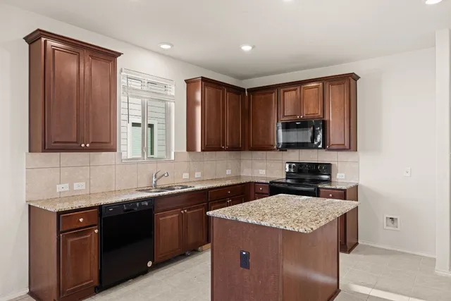 a kitchen with stainless steel appliances granite countertop a sink stove and cabinets