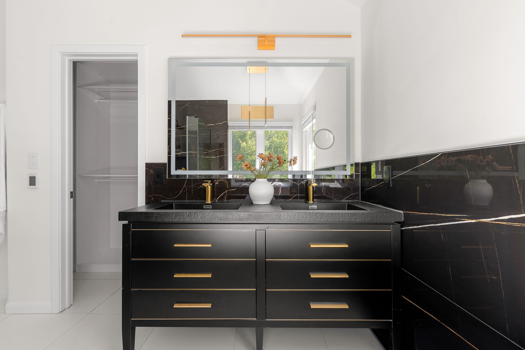 6500 Clay Allison Pass Austin, TX 78749 - Photo 27 of 39 Double vanity featuring a black countertop with integrated sinks and gold-tone faucets