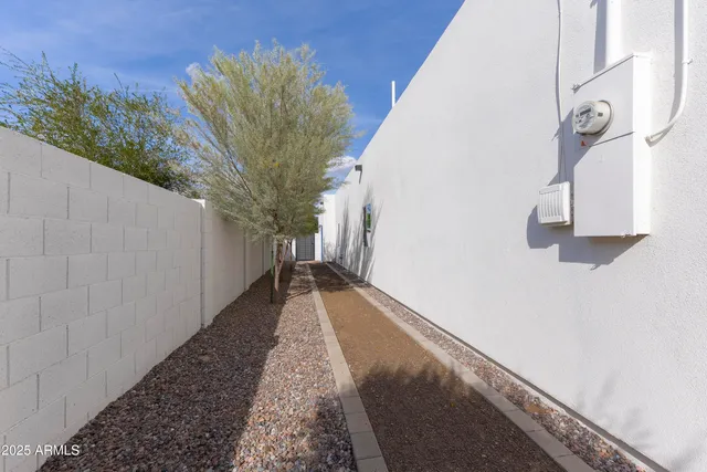 a view of a pathway of a house with wooden fence