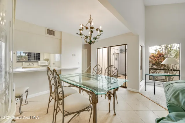 a view of a dining room with furniture a chandelier and wooden floor