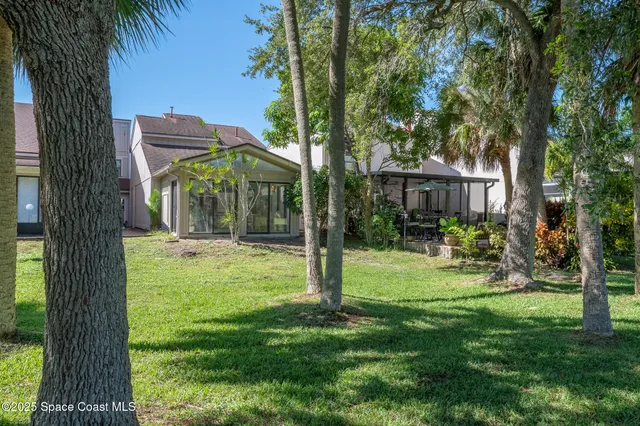 a view of a house with a backyard and a tree