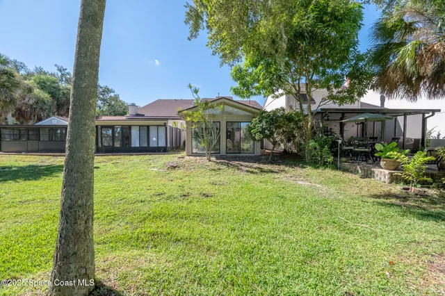 a view of a house with backyard and tree