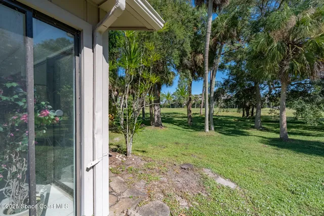 a backyard of a house with table and chairs