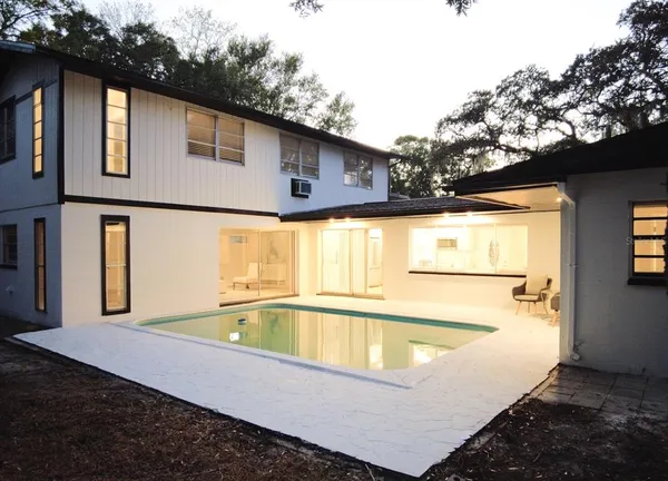 a view of a house with pool and a yard