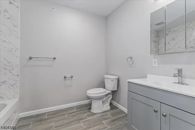 a bathroom with a sink toilet and a mirror
