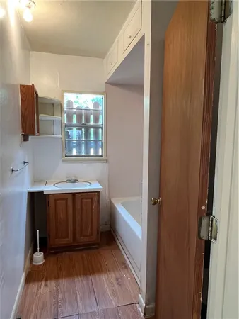 a bathroom with a tub sink and mirror