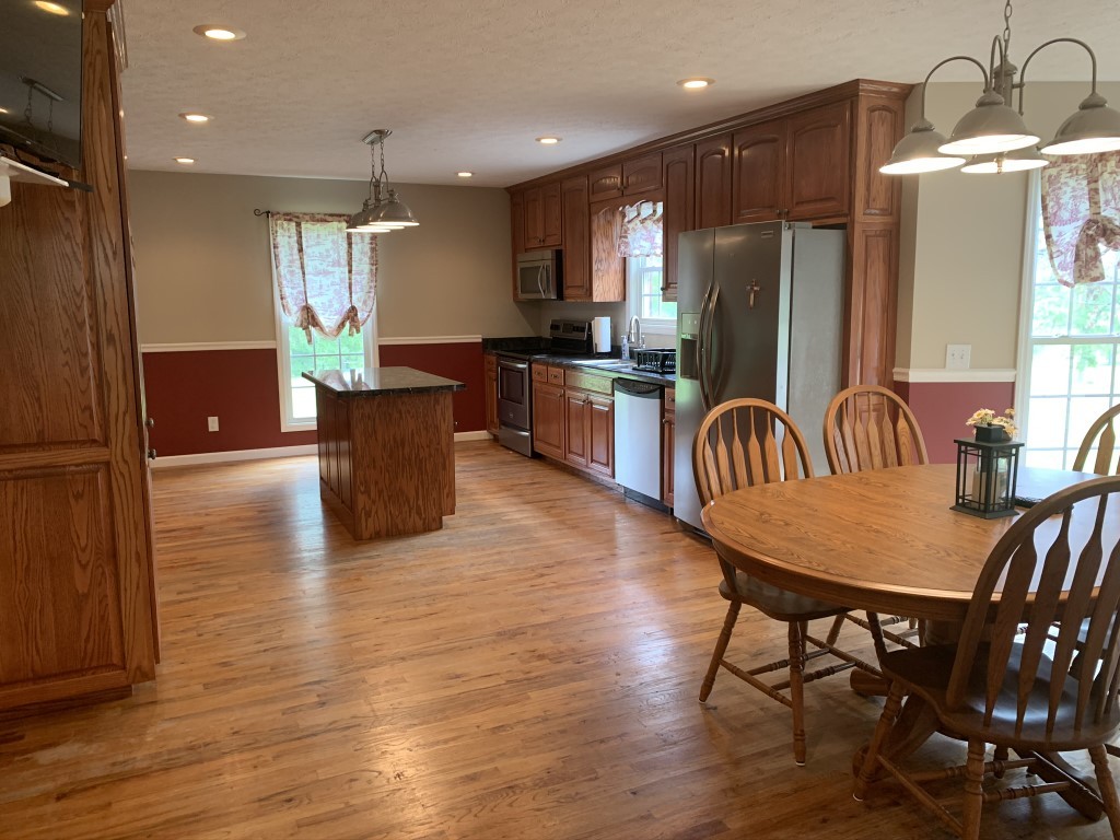 579 Rocky Road Liberty, TN 37095 - Photo 31 of 44 a kitchen with stainless steel appliances kitchen island granite countertop a refrigerator a stove a sink dishwasher a dining table and chairs with wooden floor