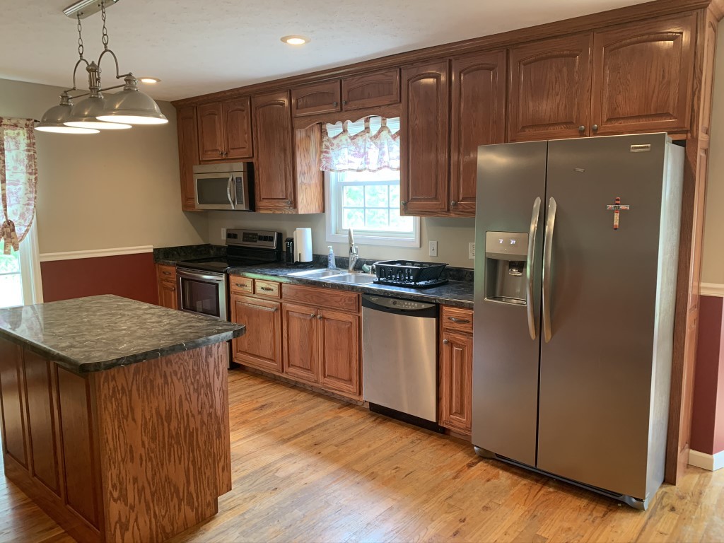 579 Rocky Road Liberty, TN 37095 - Photo 33 of 44 a kitchen with stainless steel appliances granite countertop a refrigerator a sink dishwasher a stove with wooden cabinets and floor