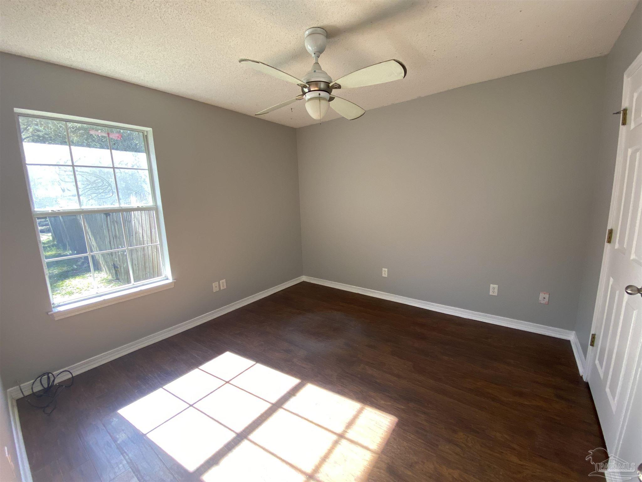 5493 Riviera Drive Milton, FL 32583 - Photo 12 of 21 wooden floor in an empty room with a window