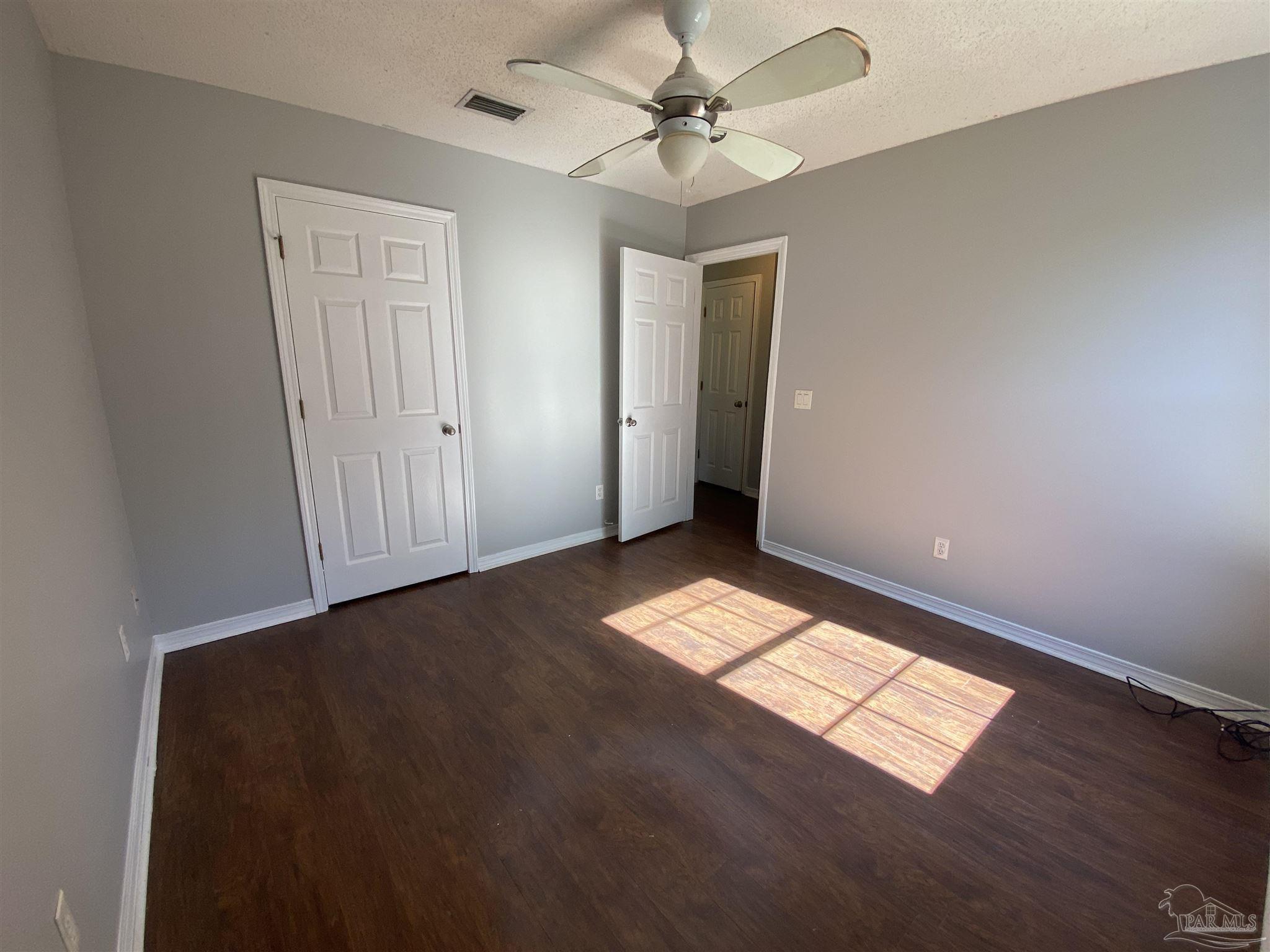 5493 Riviera Drive Milton, FL 32583 - Photo 13 of 21 a view of empty room with wooden floor and fan