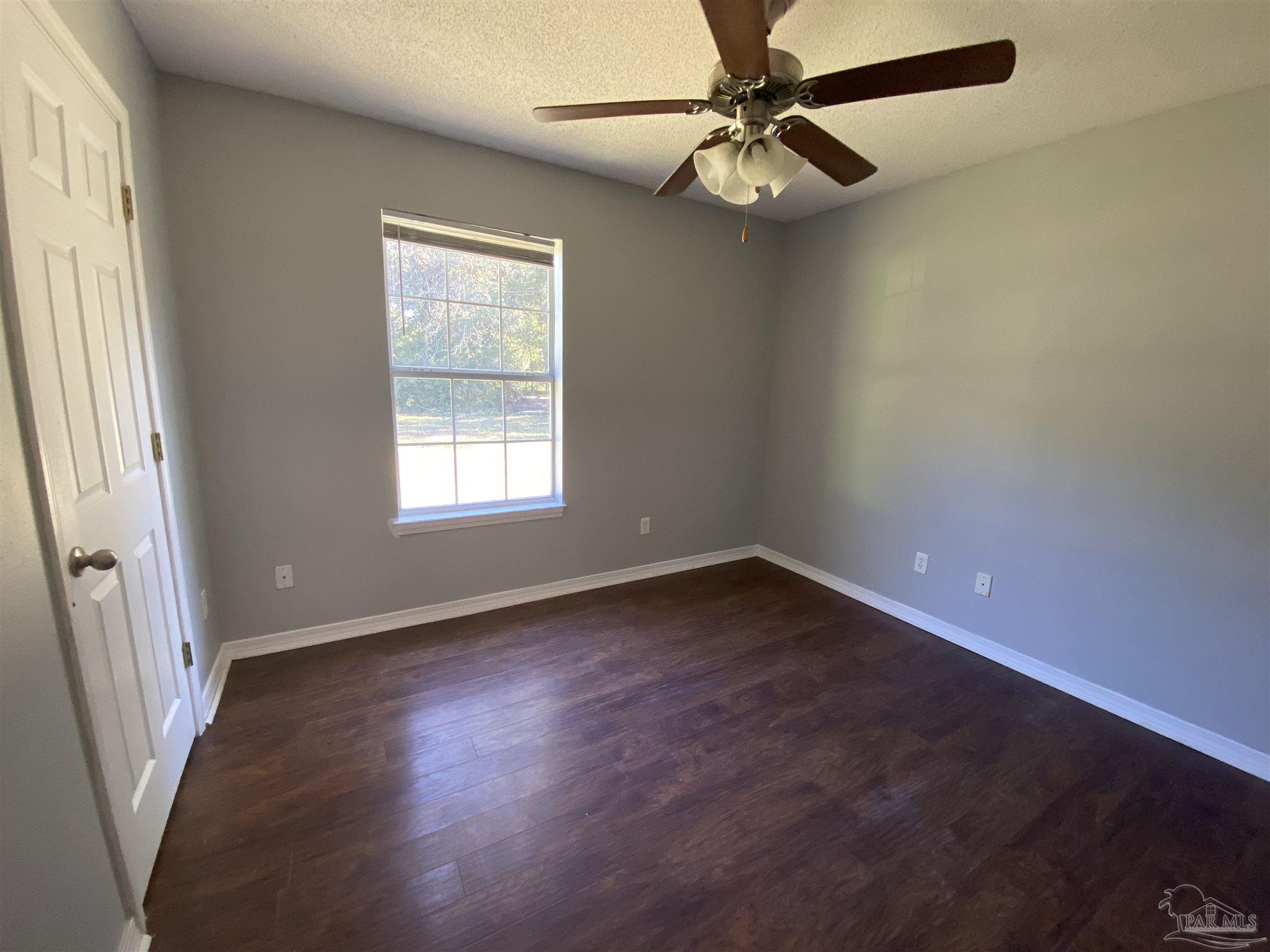 5493 Riviera Drive Milton, FL 32583 - Photo 14 of 21 an empty room with a window and a fan
