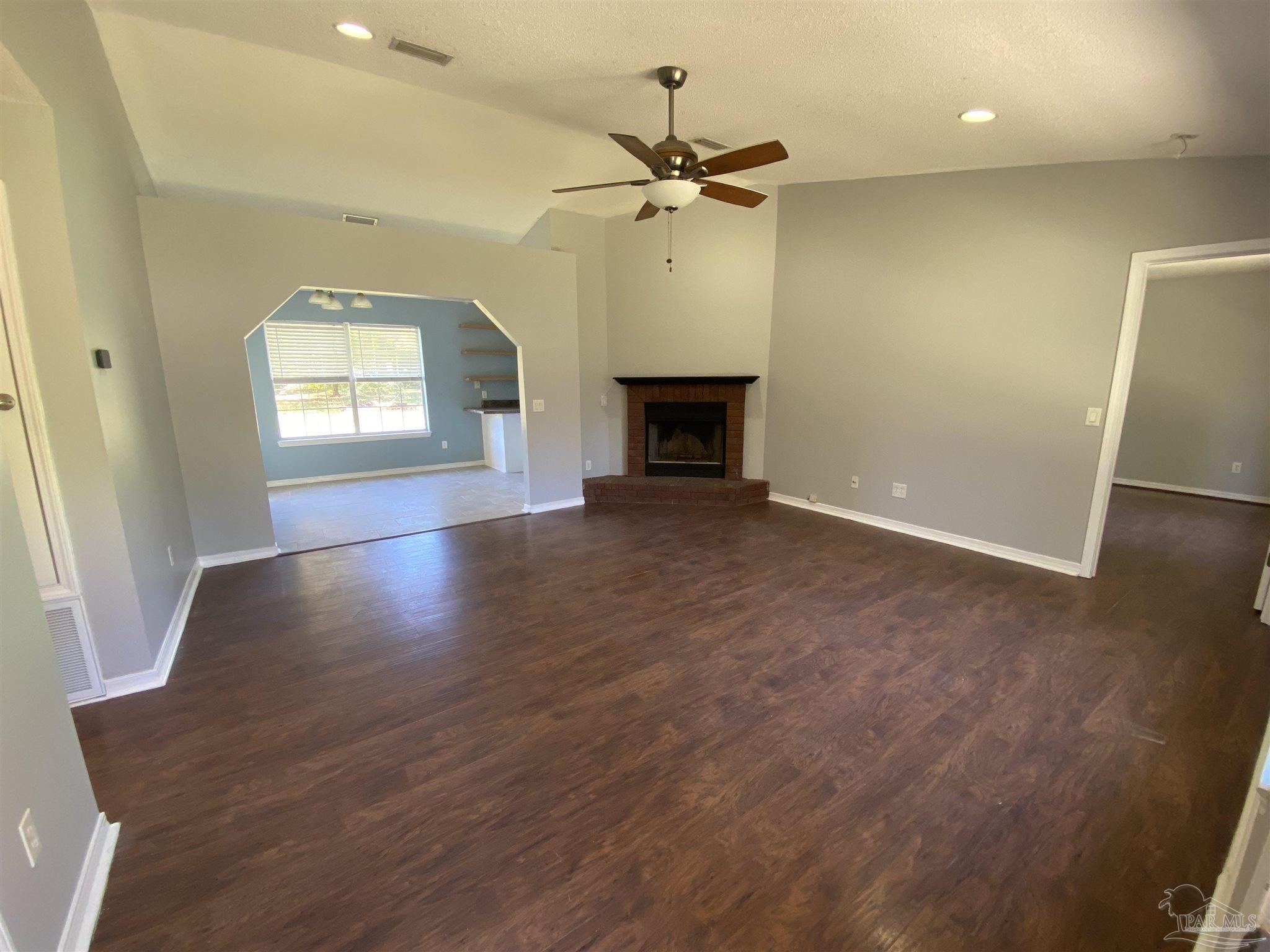 5493 Riviera Drive Milton, FL 32583 - Photo 2 of 21 an empty room with windows and a fireplace
