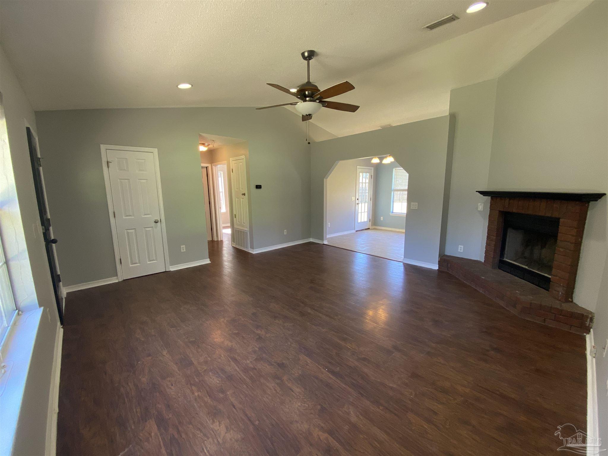 5493 Riviera Drive Milton, FL 32583 - Photo 3 of 21 wooden floor in an empty room with a window
