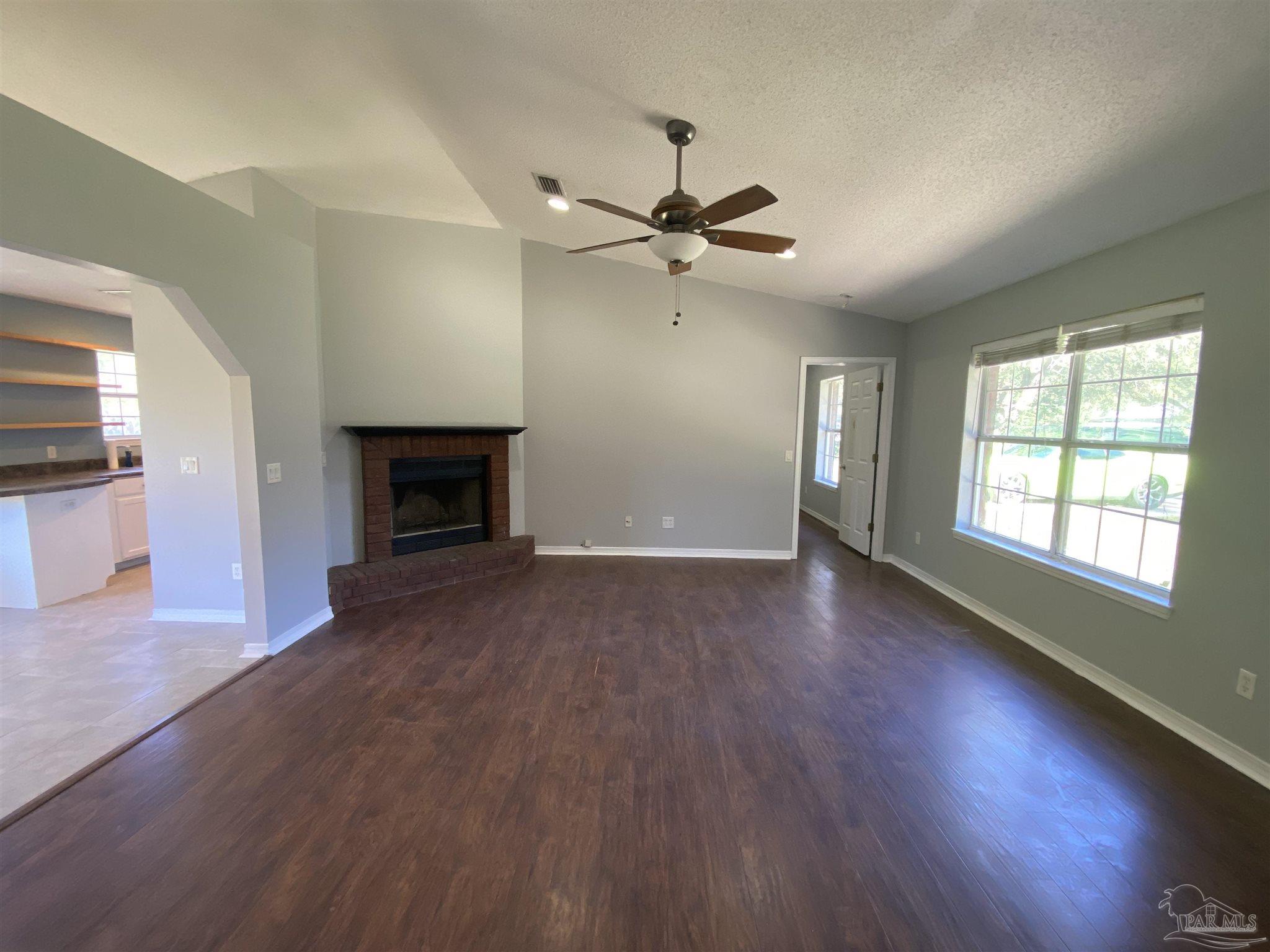 5493 Riviera Drive Milton, FL 32583 - Photo 4 of 21 a view of empty room with wooden floor and fireplace
