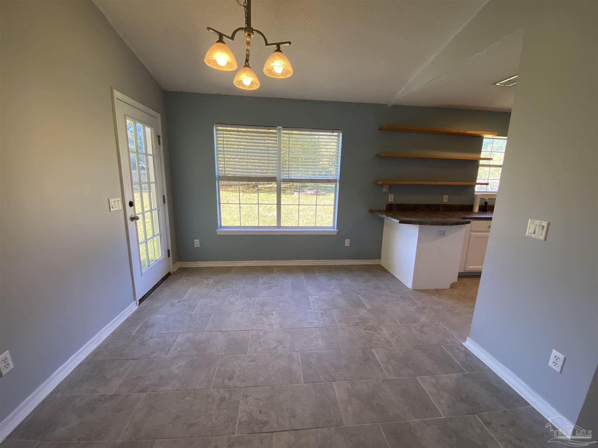 5493 Riviera Drive Milton, FL 32583 - Photo 6 of 21 an empty room with a fireplace and windows