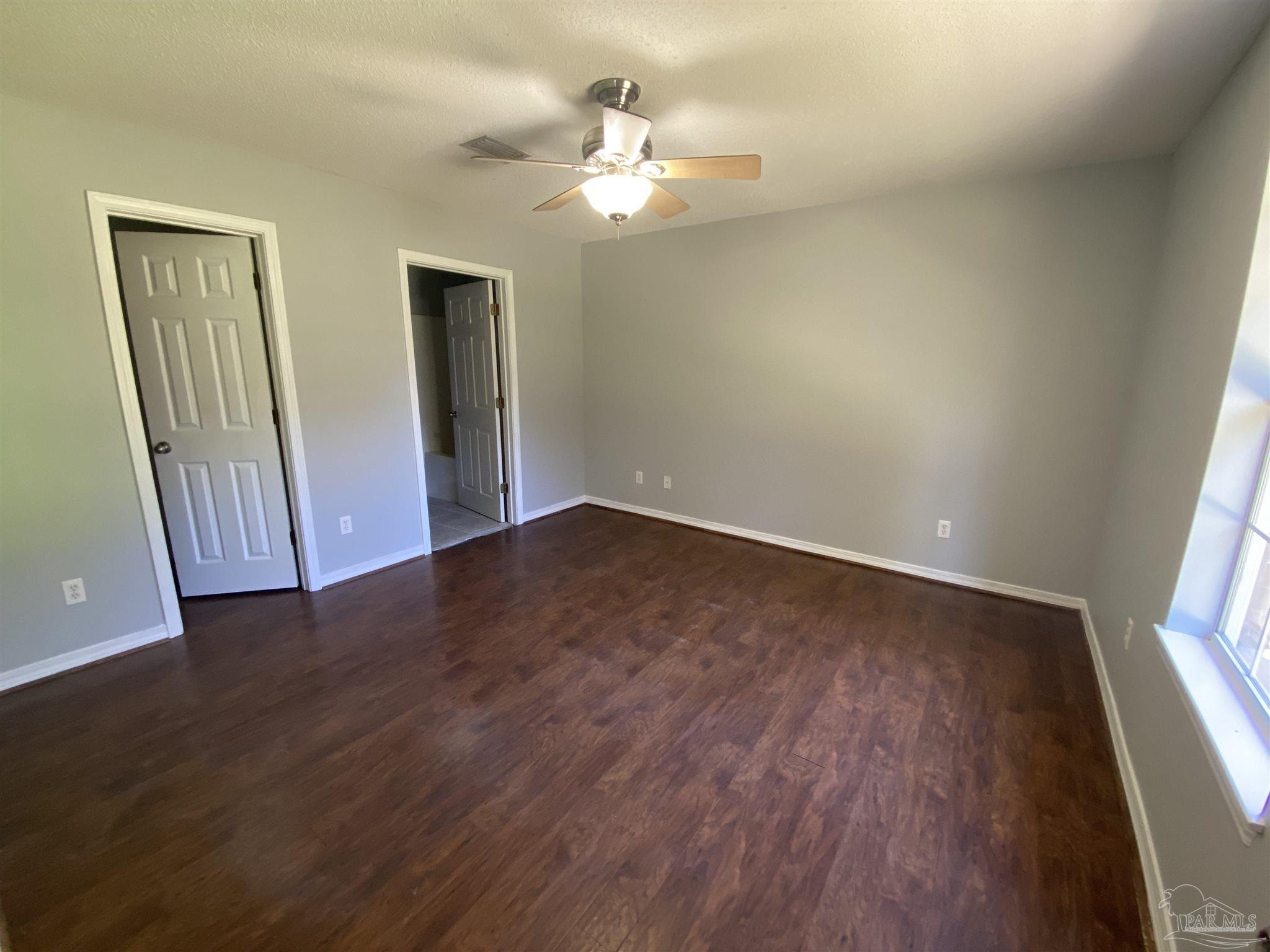5493 Riviera Drive Milton, FL 32583 - Photo 10 of 21 wooden floor in an empty room with a window