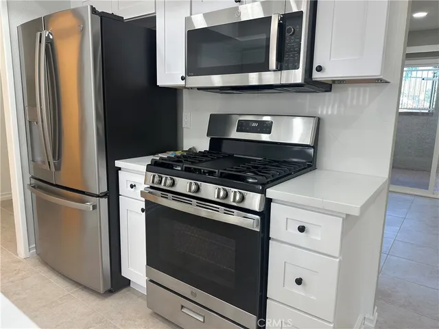 a kitchen with stainless steel appliances granite countertop a refrigerator stove and microwave
