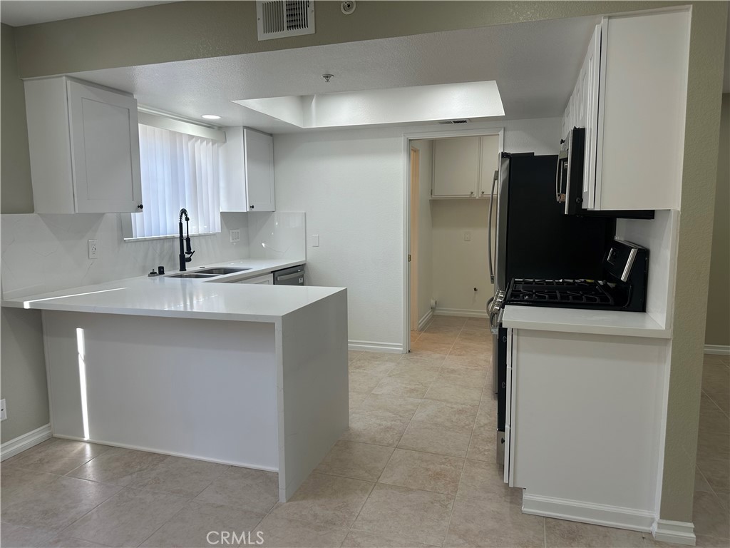 201 Laurel Avenue, Unit 6 Brea, CA 92821 - Photo 6 of 24 a kitchen with a sink cabinets and refrigerator