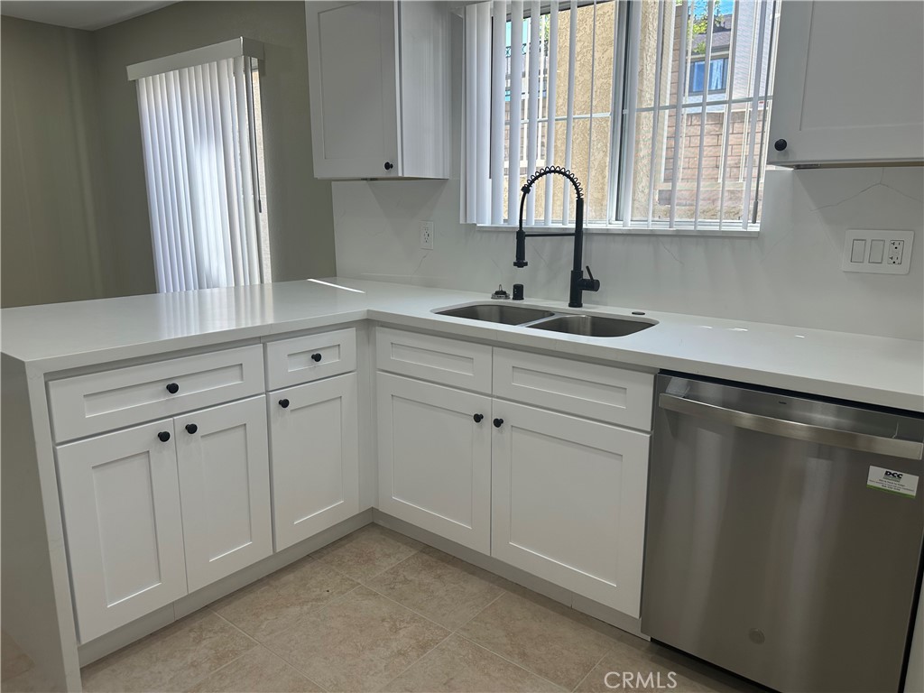 201 Laurel Avenue, Unit 6 Brea, CA 92821 - Photo 7 of 24 a kitchen with white cabinets and a sink