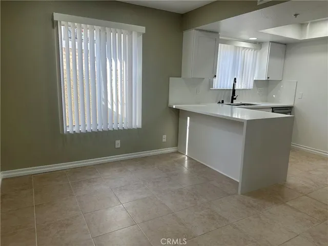 a kitchen with kitchen island granite countertop a sink window and cabinets