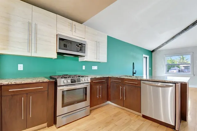 a kitchen with stainless steel appliances kitchen island granite countertop a sink and cabinets