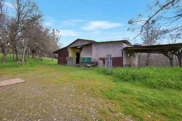 a view of a house with a yard and large tree