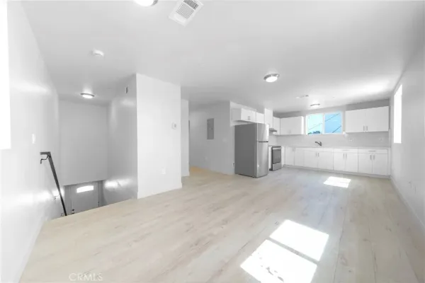a view of a kitchen with a sink and refrigerator