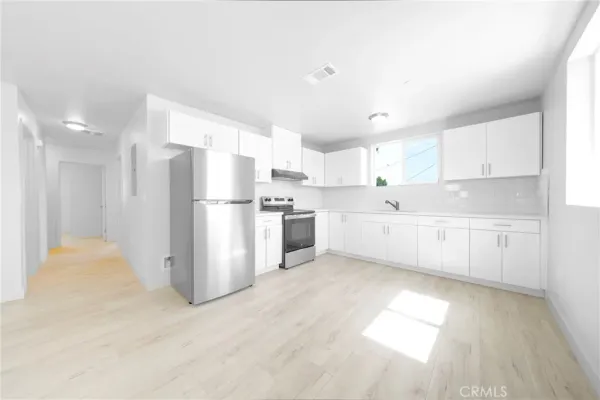 a kitchen with stainless steel appliances a refrigerator sink and cabinets