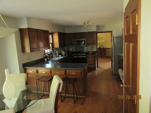 a kitchen with a table chairs refrigerator and cabinets