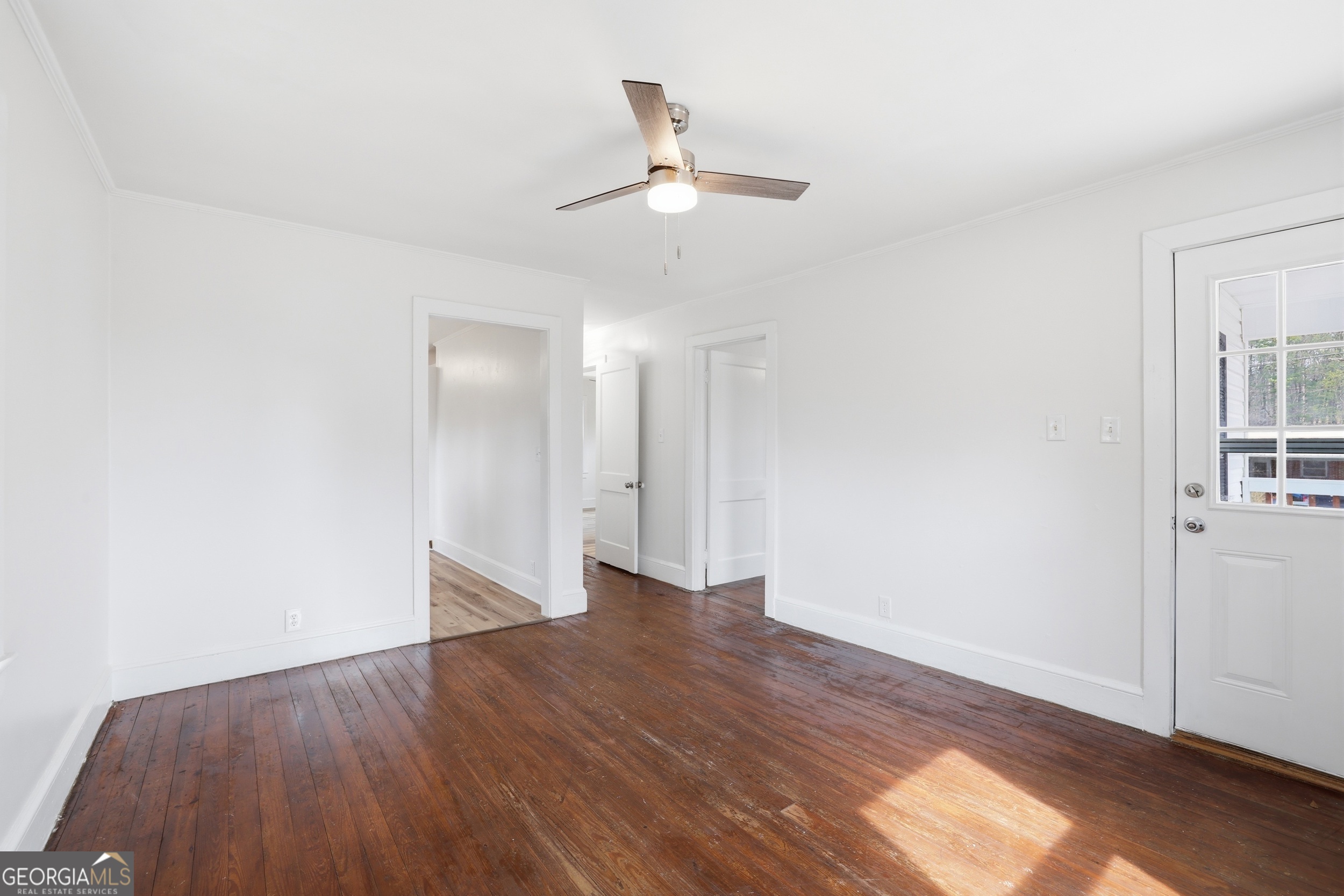 481 Collins Road Toccoa, GA 30577 - Photo 18 of 54 a view of an empty room with wooden floor and a ceiling fan
