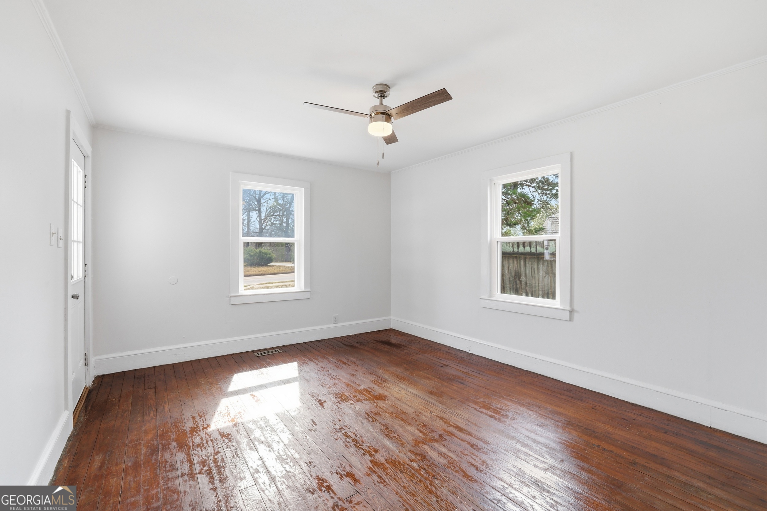 481 Collins Road Toccoa, GA 30577 - Photo 20 of 54 an empty room with wooden floor ceiling fan and windows