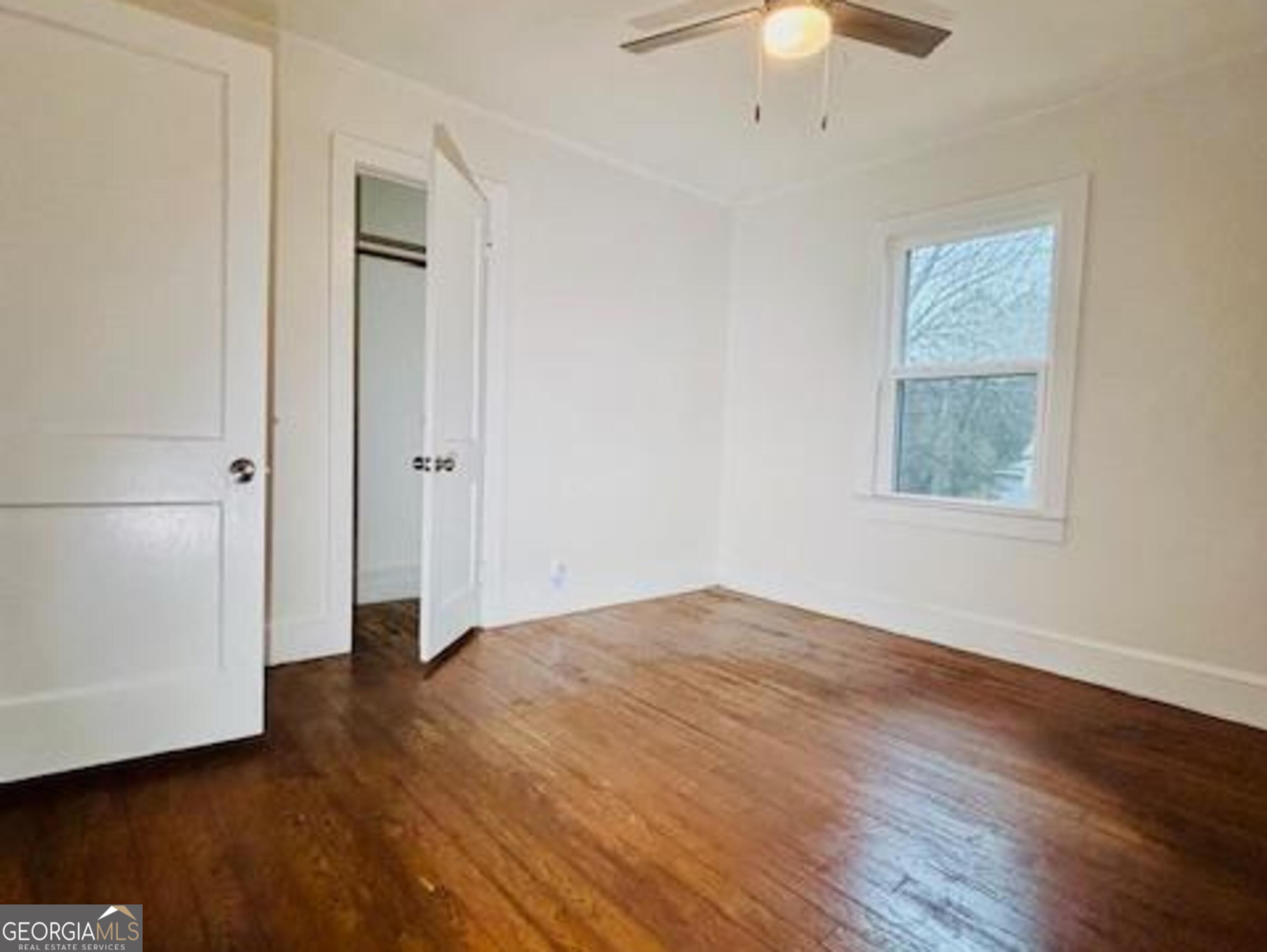 481 Collins Road Toccoa, GA 30577 - Photo 23 of 54 a view of an empty room with wooden floor a ceiling fan and a window