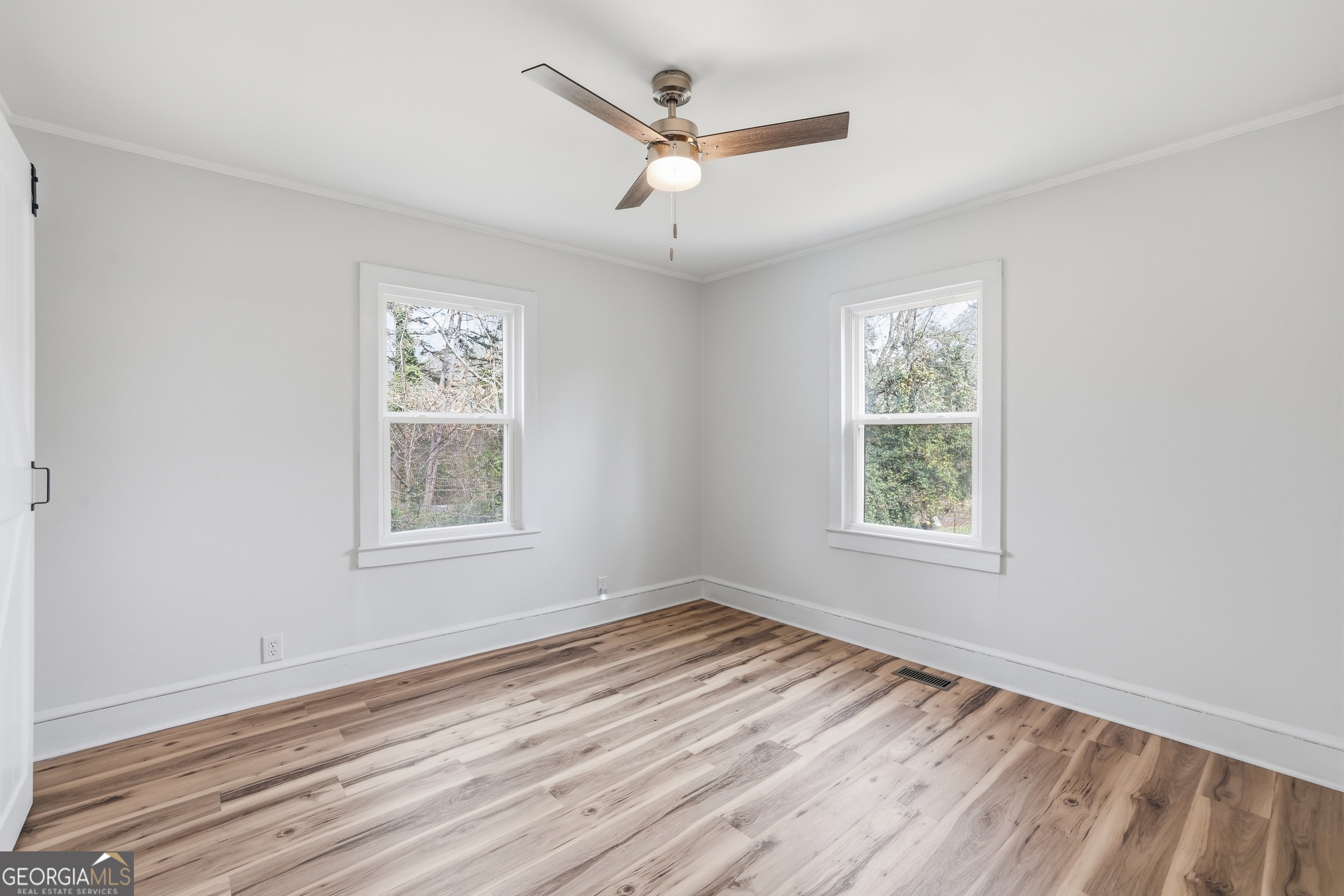 481 Collins Road Toccoa, GA 30577 - Photo 26 of 54 an empty room with wooden floor ceiling fan and windows