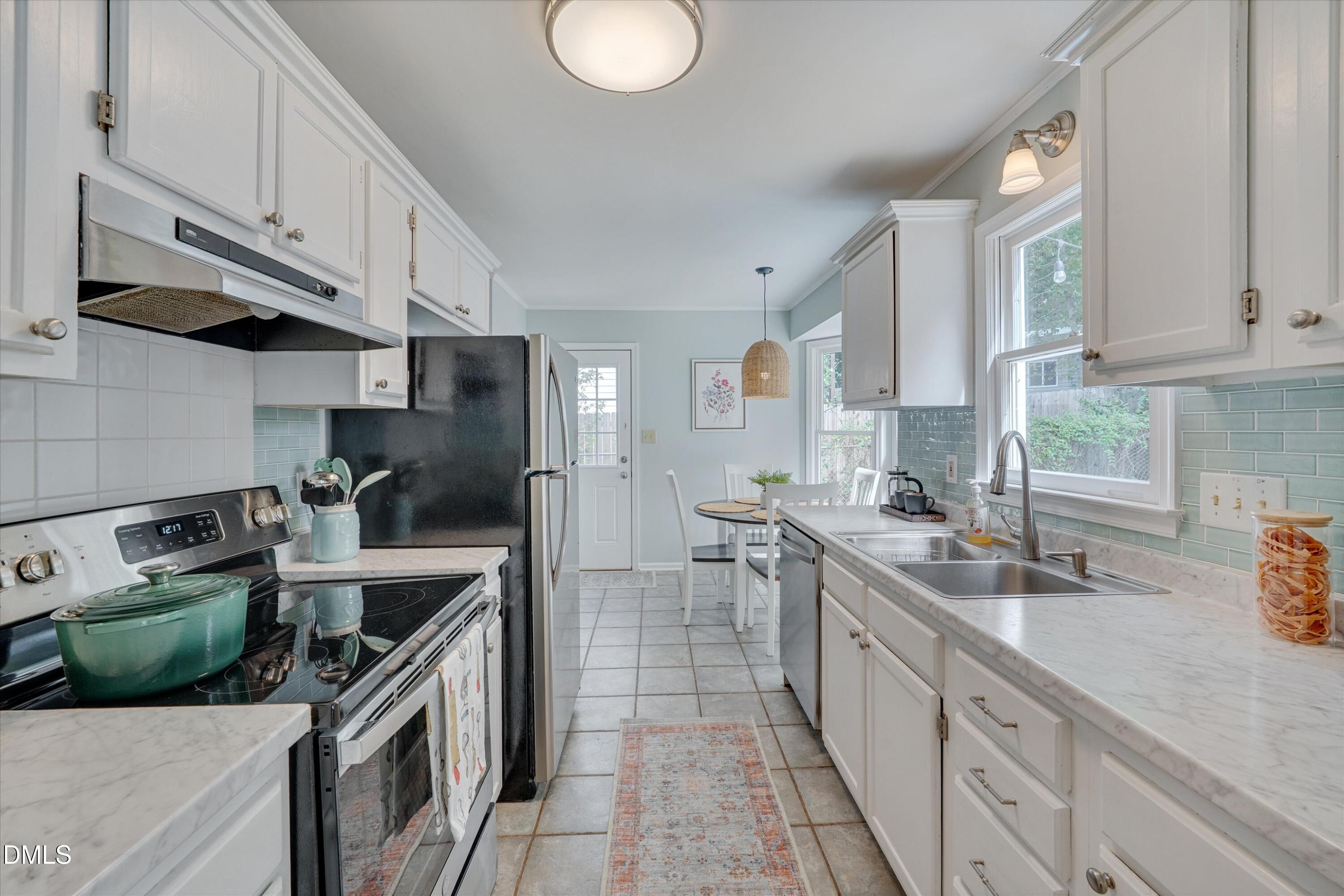 3301 Lassiter Street Durham, NC 27707 - Photo 12 of 32 a kitchen with stainless steel appliances granite countertop a sink stove and refrigerator
