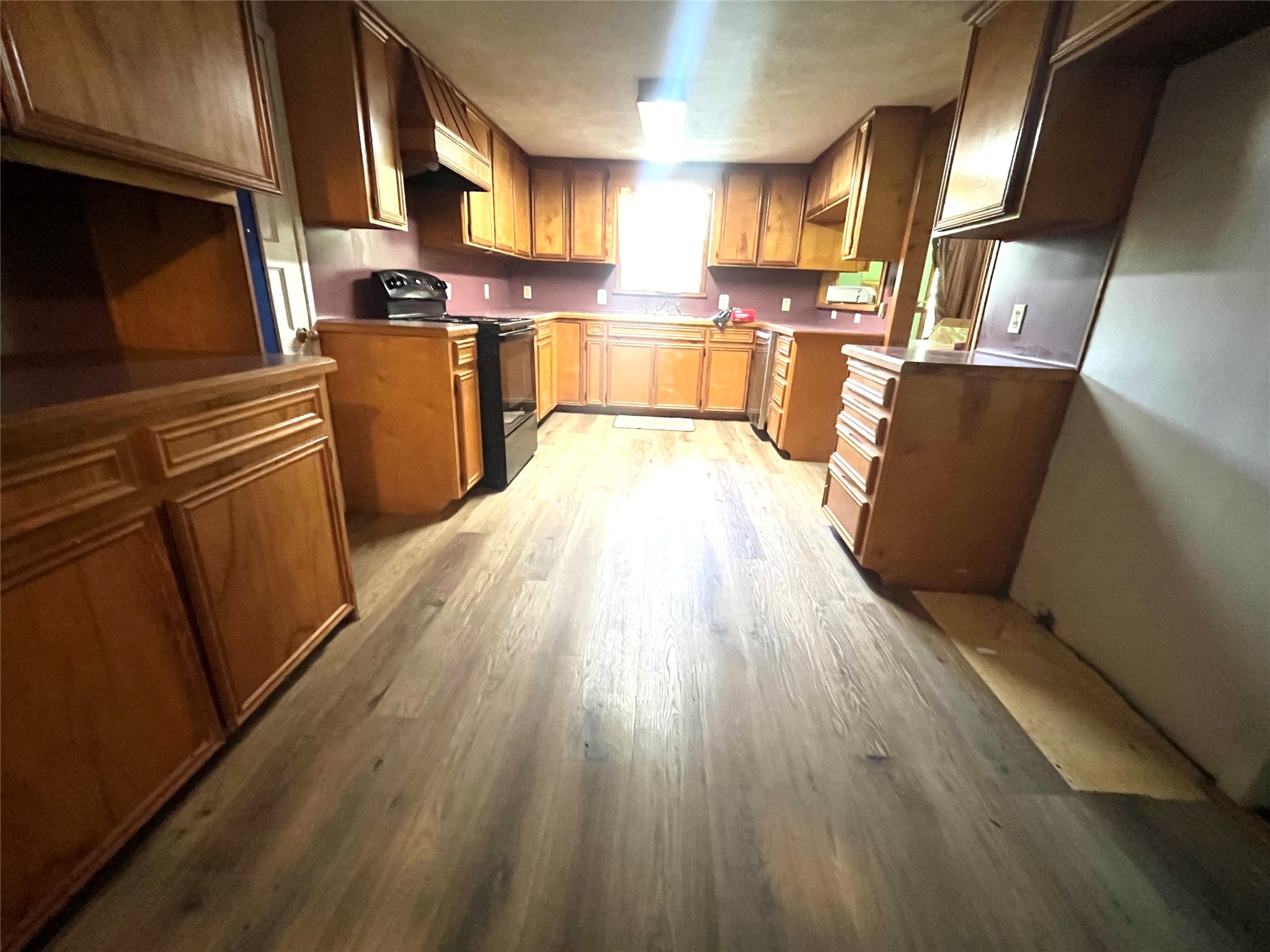 50 3rd Street Shepherd, TX 77371 - Photo 3 of 6 a kitchen with stainless steel appliances wooden floors and wooden cabinets