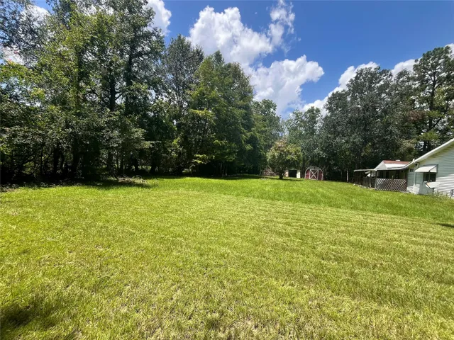 a view of a green field with wooden fence