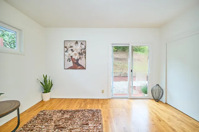 a view of a bedroom with wooden floor and a rug