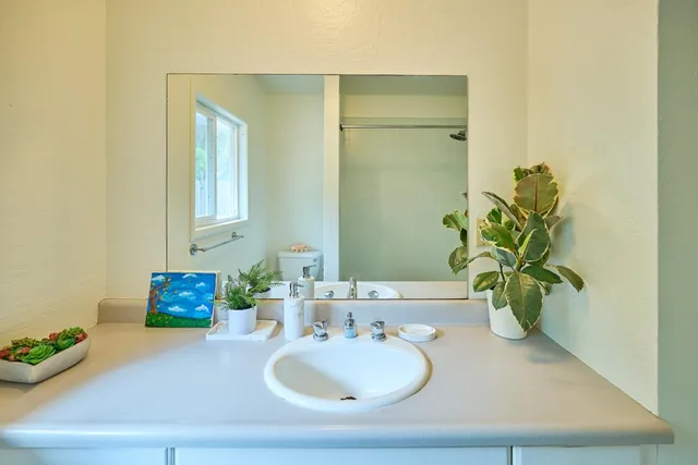 a bathroom with a granite countertop sink a mirror and vanity