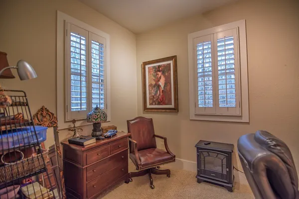 a view of a workspace with furniture and a window