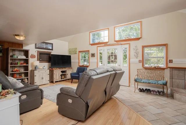 a living room with furniture a flat screen tv and a window