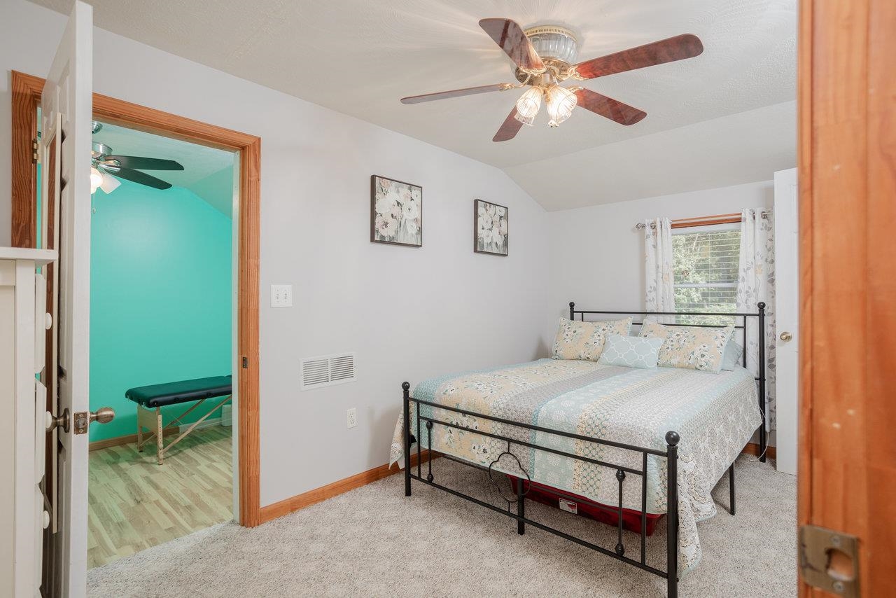 279 Helms Road Stanley, VA 22851 - Photo 38 of 64 a bedroom with a bed and a chandelier