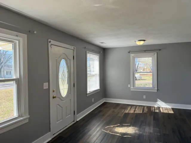 a view of a livingroom with wooden floor and window