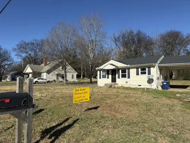 a front view of a house with yard and green space