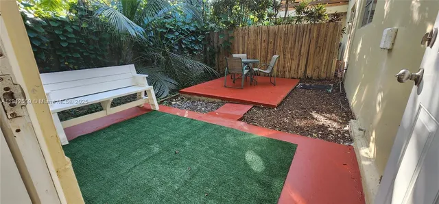 a view of a backyard with chairs and a patio