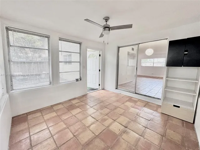 a view of empty room with a window and ceiling fan
