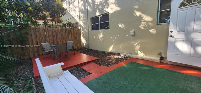 a backyard of a house with table and chairs